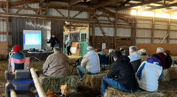 Extension talk in a bar with people sitting on haybales