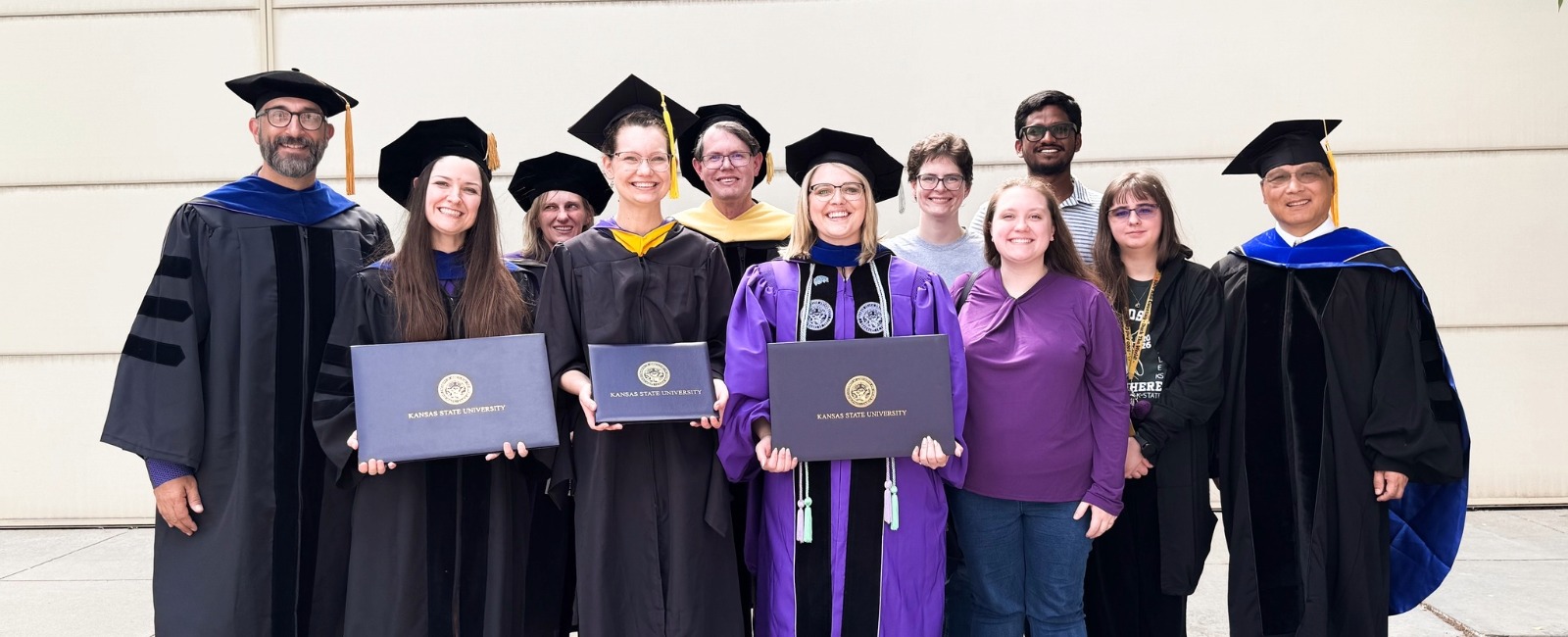 graduate students at commencement with department members